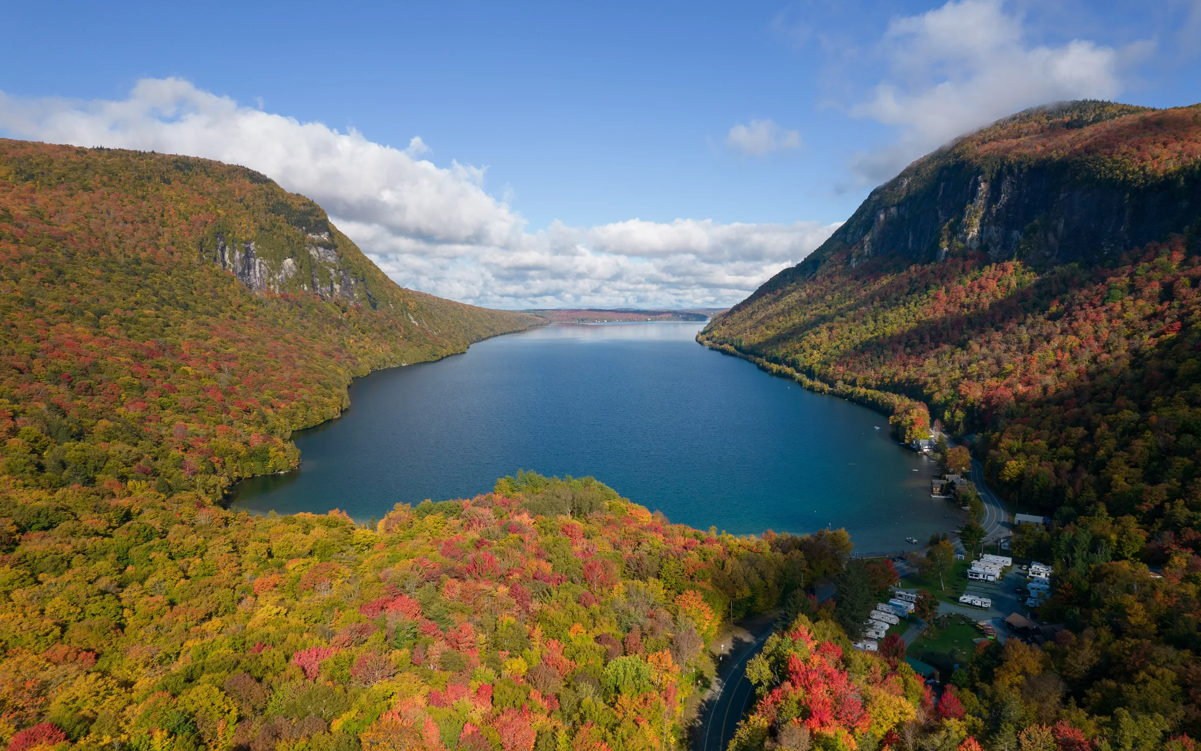 An autumn lake ringed by red and gold foliage in the Green Mountains