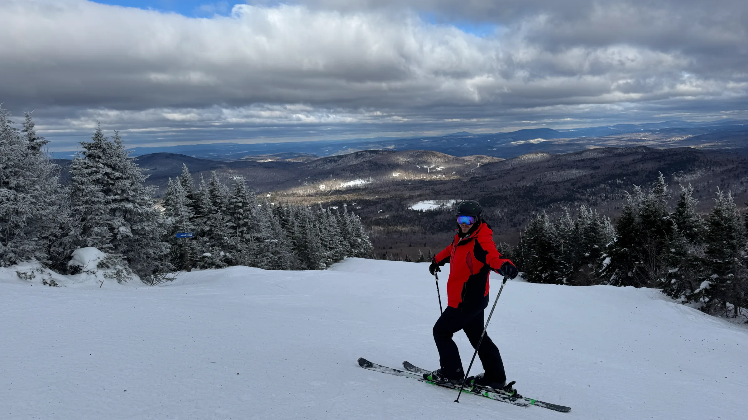 A skier above the snow-covered Green Mountains at Stratton