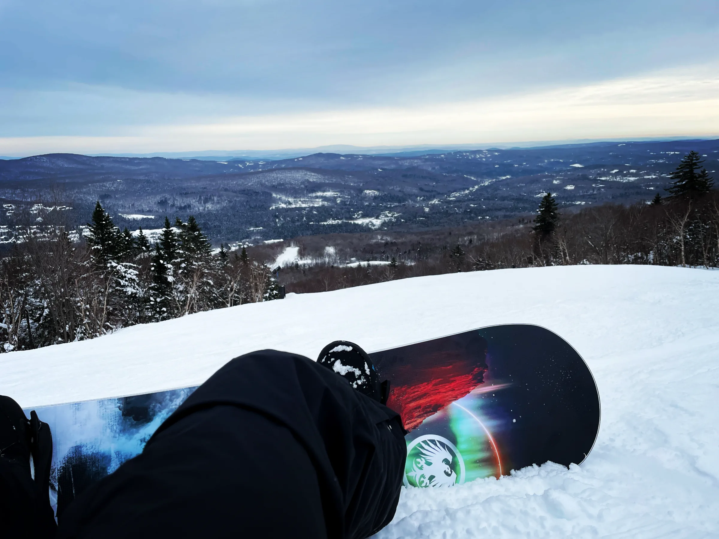 A snowboarder's view over the valley from the summit