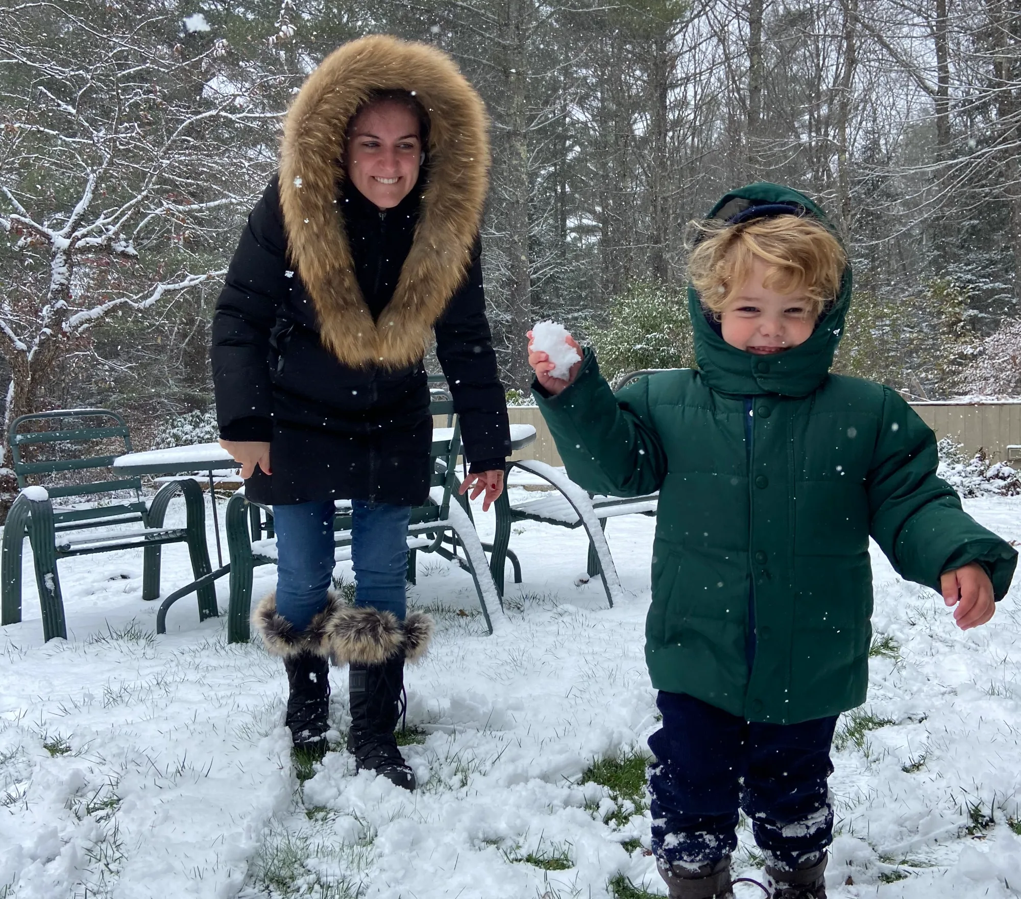 A guest and child playing in fresh snow at the chalet