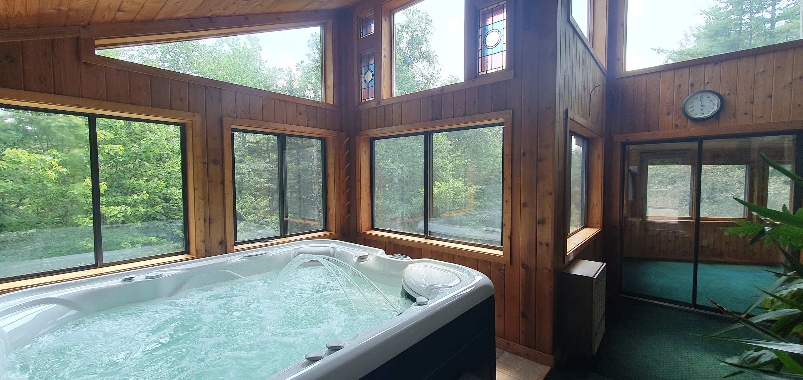 The glass-walled sun-room with the hot tub