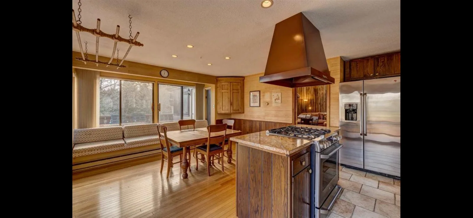 The kitchen with breakfast banquette and stainless appliances